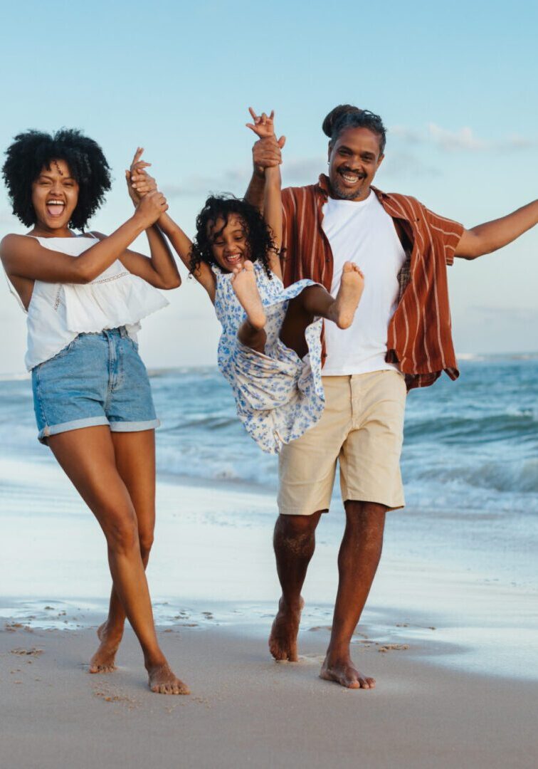 Happy family enjoying vacation on the beach together Family joyfully walking on the beach together.